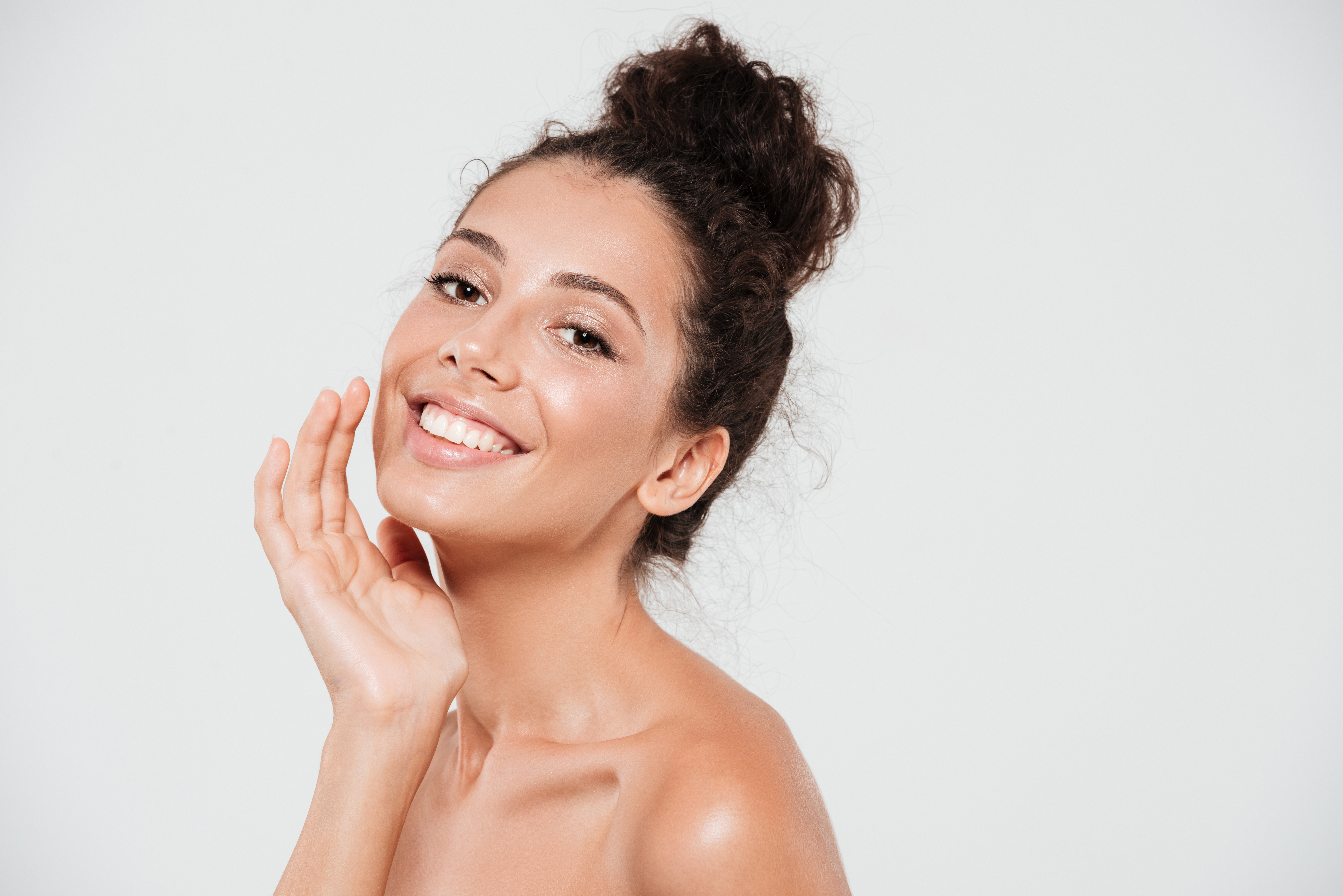 Beauty portrait of a smiling pretty woman with healthy skin looking at camera and posing isolated over white background